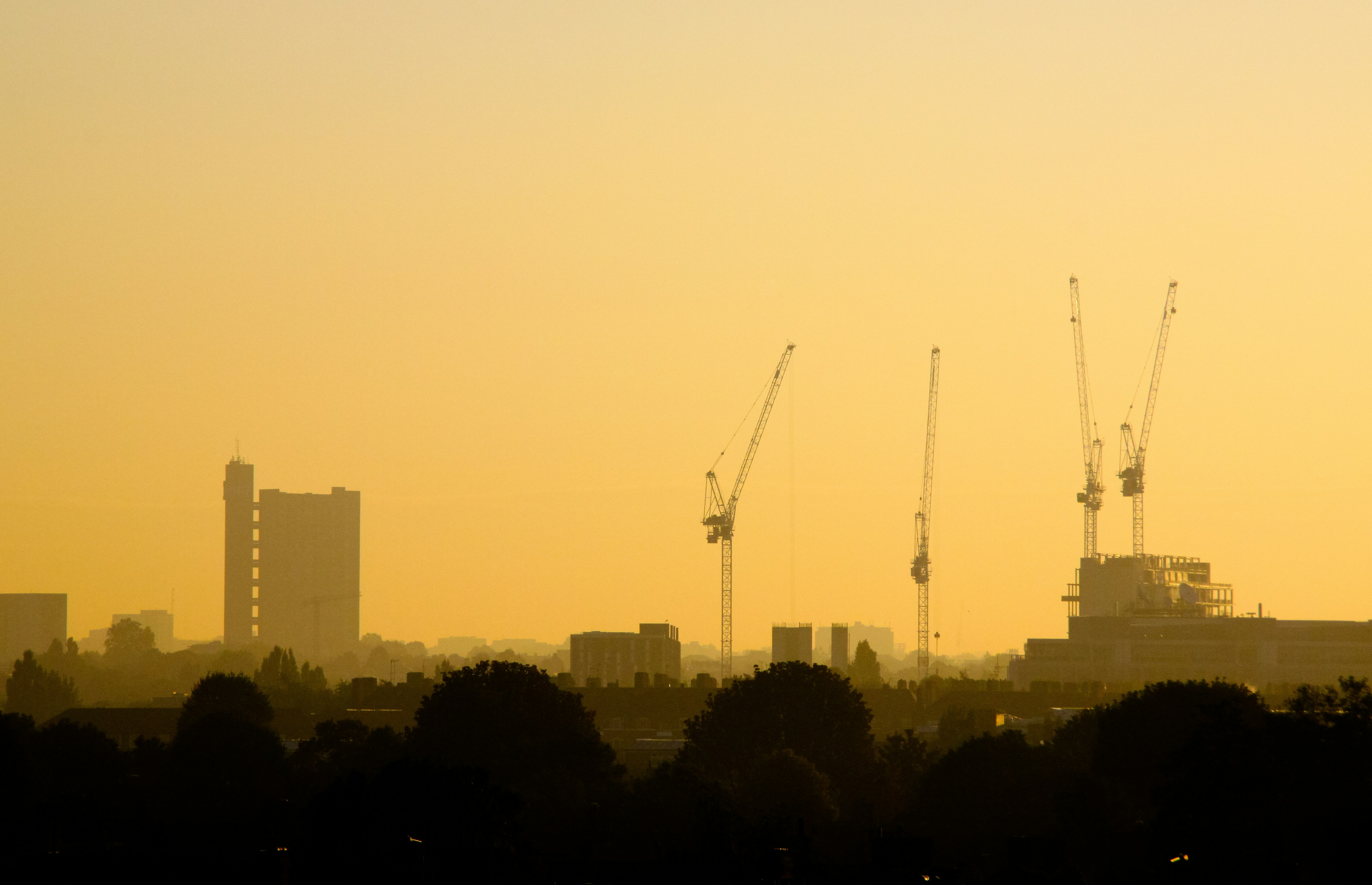 Construction cranes at sunset across UK skyline